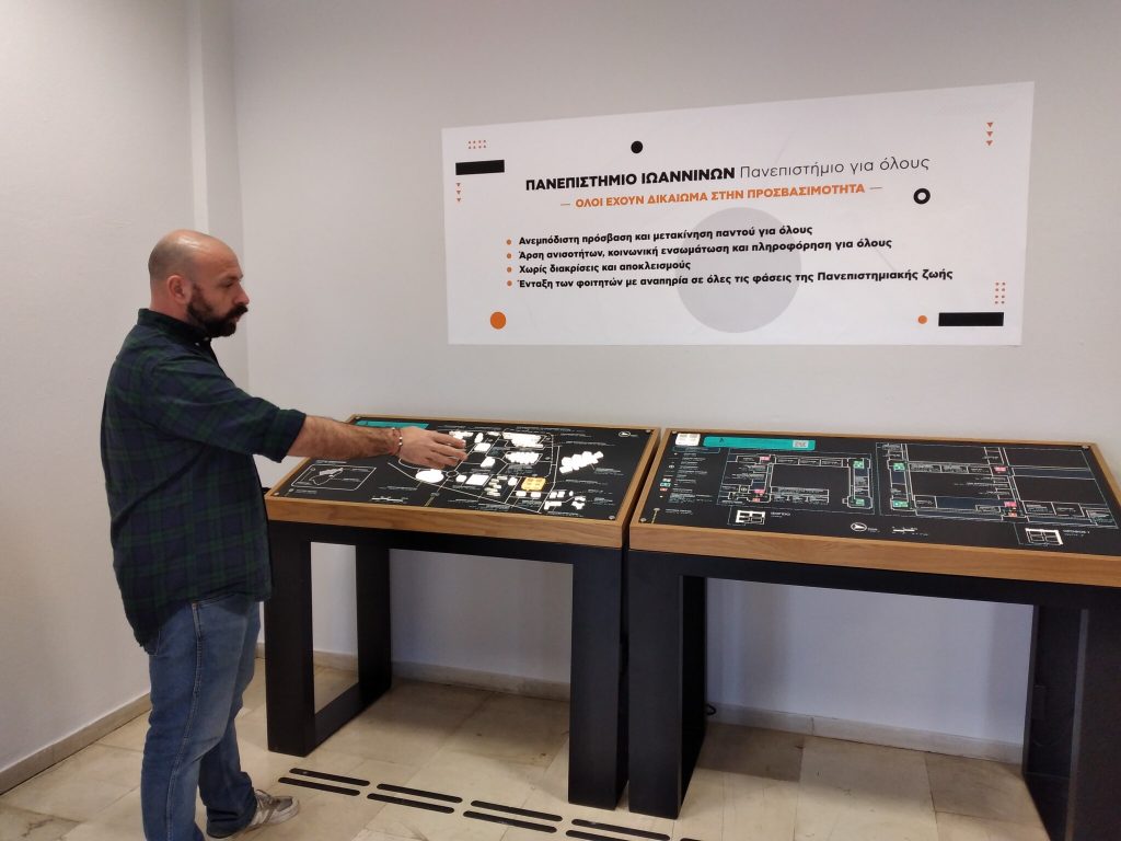 Ο κατασκευαστής εξηγεί μπροστά απο τους απτικούς χάρτες, την λειτουργία τους